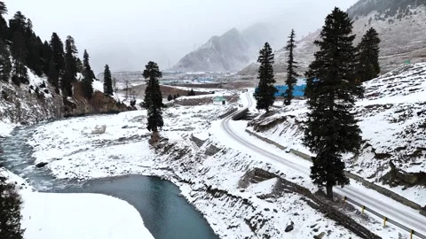 Drone flying low above blue winter water, exposing a pristine snow-blanketed Stock Footage 310223763