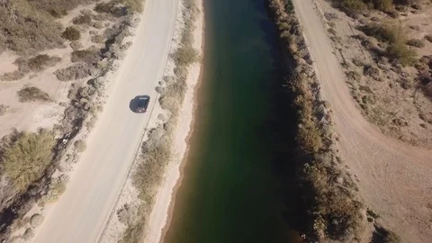 Drone flying low following a pick up truck driving along the Gila Gravity Stock Footage 122907877