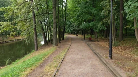Drone flying low forward along park path Vidéo 326359157
