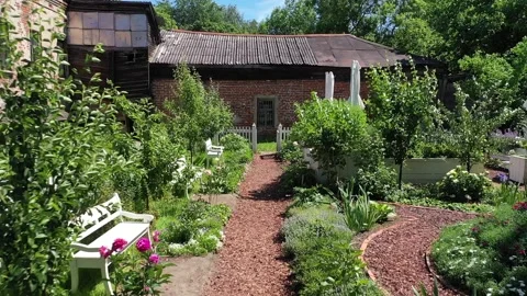 Drone flying low forward through inner yard Vidéo 327328301