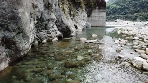 Drone flying low over clear flowing river and rocks and mountains (Taiwan) Stock Footage 329052277