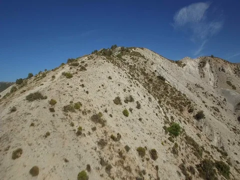 Drone flying low over desert landscape to a tourist hiking at the top Stock Footage 73472533