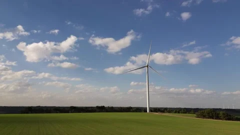 Drone Flying Low Over Green Cereal Field Approaching Wind Turbine Under Blue Sky Stock Footage 331118343