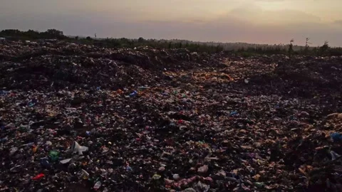 Drone flying low over a large patch of garbage on a landfill at sunset in Stock Footage 311511432