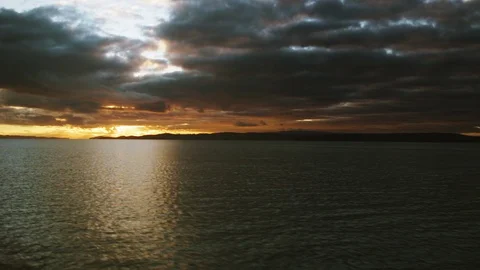 Drone flying low over the ocean at sunset Vídeos de archivo 87720817