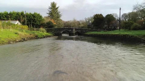 Drone Flying Low Over River Toward Old Stone Bridge in Lerryn, Cornwall Stock Footage 328054139