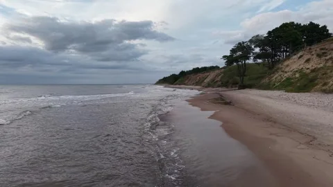 Drone flying low over sea waves, relaxing sand cliff views, Ulmale Latvia Stock Footage 341770274
