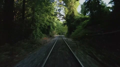 Drone flying low over train tracks with a deer running off to the left Stock Footage