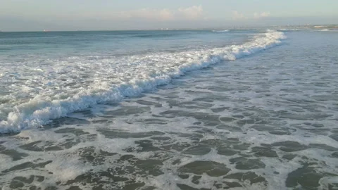 Drone flying low over waves thats rolling towards coastline Stock-Footage 153390977