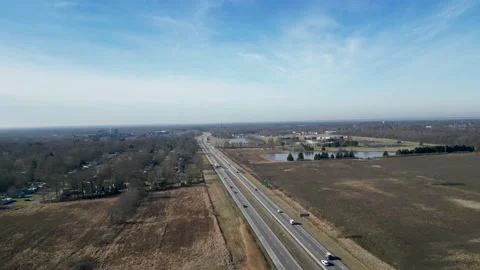 Drone flying in middle of winter in Ohio overhead a 2 lane highway with a Video stock 232387280