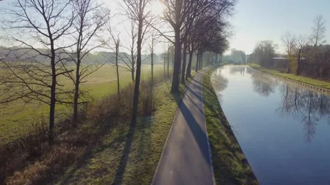 Drone flying up next to a river or canal and farm fields in Belgie around Stock Footage 166690100