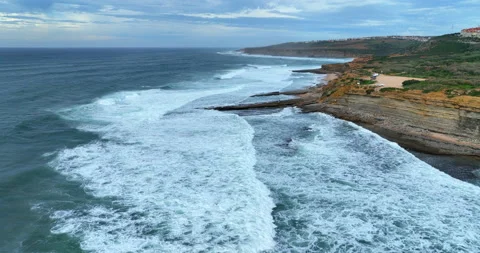 Drone flying over the Atlantic ocean foamy waves rolling at rocky shore. Aerial Stock Footage 221721445