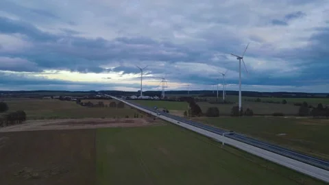 Drone flying over autobahn with fields, cars and wind turbines Stock Footage 159672665