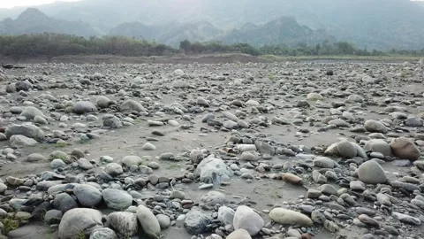 Drone flying over barren riverside rocks and mountains (Taiwan) Stock Footage 329052260