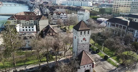 Drone flying over Basel City Switzerland beside River Rhein pan around churc Stock Footage 140280224