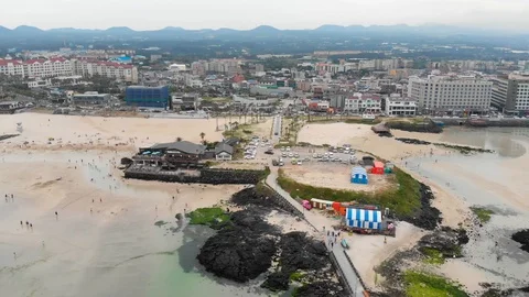 Drone flying over beach restaurant and car park towards town Stock Footage 91092246