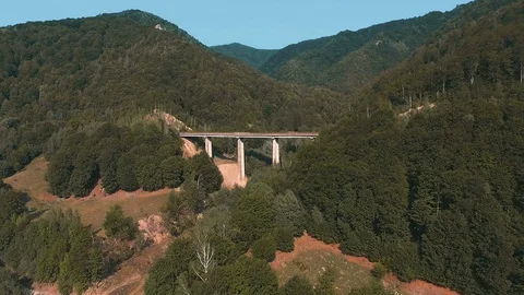 Drone flying over bridge between hills Stock Footage 129849557
