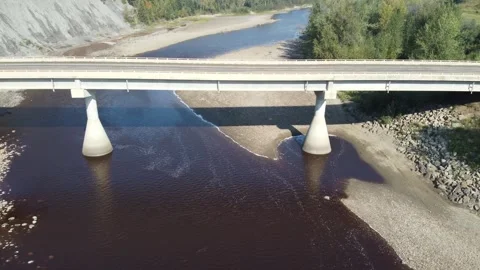 Drone flying over bridge over river while car drives across on sunny day 스톡 동영상 279944438