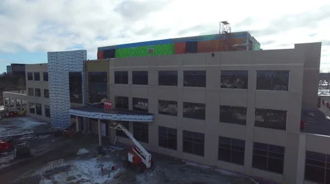Drone flying over building under construction revealing town Stock Footage 64142857