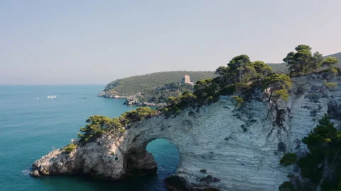 Drone flying over cave at coast with blue crystal clear water and rocks 4K Stock Footage 145670108