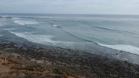 Drone Flying Over Cliff to Ocean and Surfers Video stock 84748211