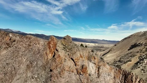 Drone flying over cliffside to reveal beautiful town in the valley Stock Footage 229807361