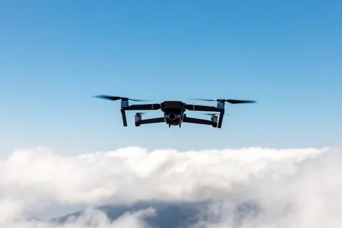 Drone flying over the clouds. Stock Photos