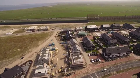 Drone flying over construction site with new housing to highway Stock Footage 75351554