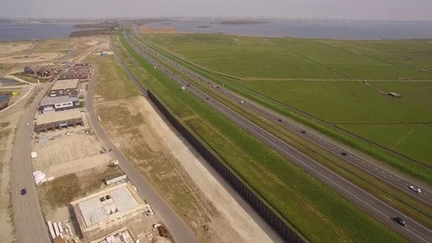 Drone flying over construction site and highway with view over dutch landscape Stock Footage 75351561