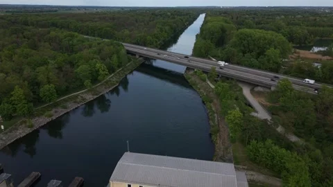 Drone flying over dam toward highway bridge with fast moving traffic Видео 334027569
