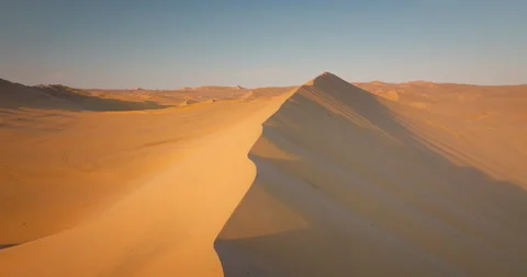 Drone Flying over Desert Sand Dunes at Golden Sunset in Huacachina, Peru Stock Footage 344363622