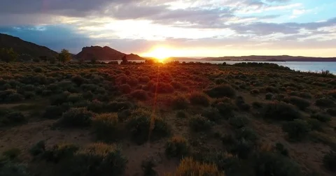 Drone flying over desert while the sun sets on the horizon in Colorado Utah land Stock Footage 82188135