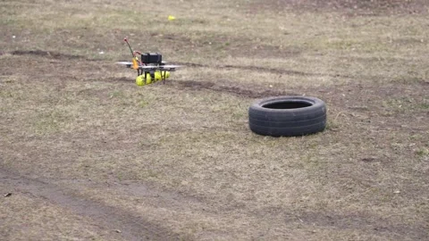 Drone flying over dirt field near tire obstacle Stock Footage 334695954