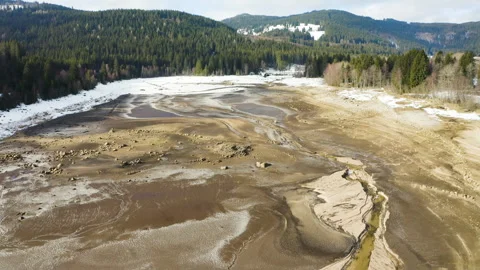 Drone flying over dried lakebed with water pools and cracked ground textures Stock-Footage 332046626