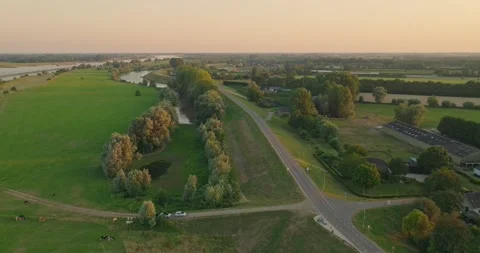 Drone Flying Over Dutch Dike Road at Sunset Along Canal and Farmland 스톡 동영상 341917554