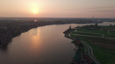 Drone flying over Dutch river and windmills toward golden sunset Stock-Footage 309313469