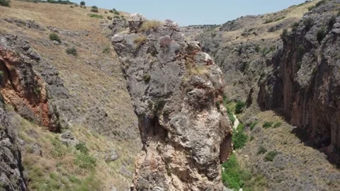 Drone flying over the edge of a deep and dramatic rocky canyon. Stock Footage 154753533