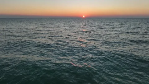 Drone flying over empty ocean with the sun on the horizon Stock Footage 345522350