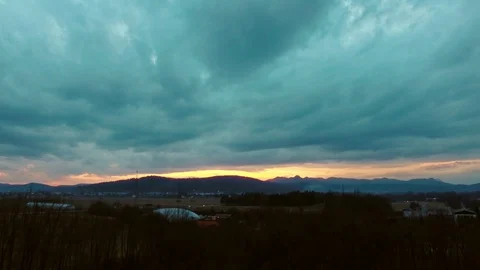 Drone flying over a field surrounded by trees showing the stormy clouds Video stock 89618790