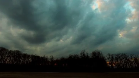 Drone flying over a field surrounded by trees showing the stormy clouds Video stock 89619057