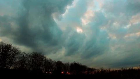 Drone flying over a field surrounded by trees showing the stormy clouds Video stock 89619284