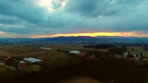 Drone flying over a field surrounded by trees showing the stormy clouds Video stock 89619412