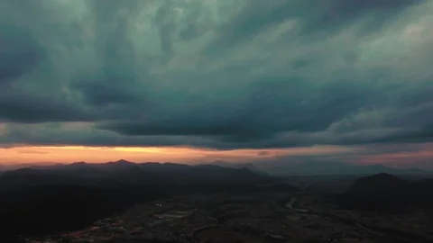 Drone flying over a field surrounded by trees showing the stormy clouds Video stock 89620094
