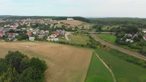 Drone flying over fields of wheat and barley in rural area road and small houses Stock Footage 136168047