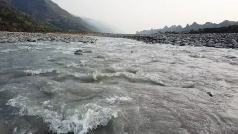 Drone flying over flowing river with mountains in the background (Taiwan) Stockbeeldmateriaal 329052268