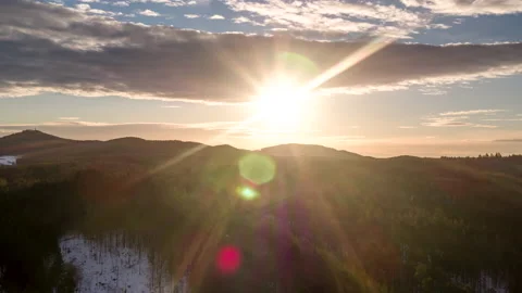 Drone flying over forest towards the sun creating sunflairs Stock Footage 147498956