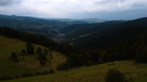 Drone flying over a forested inhabited valley 4k HDR H264 Stock Footage