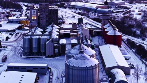 Drone flying over a grain elevator and silos in a snowy industrial winter Stock Footage 337514907