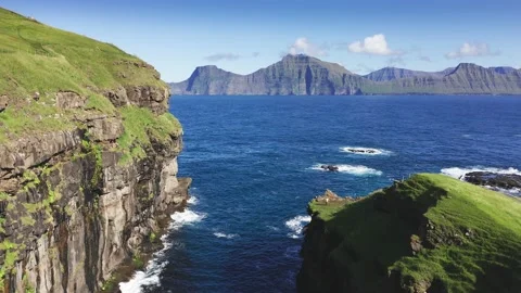 Drone flying over grass covered cliff and sea. Seagulls flying over blue rough 動画素材 156016516