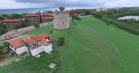 Drone is flying over a green field to an old stone tower. Bird's-eye view at Stock Footage 65536784
